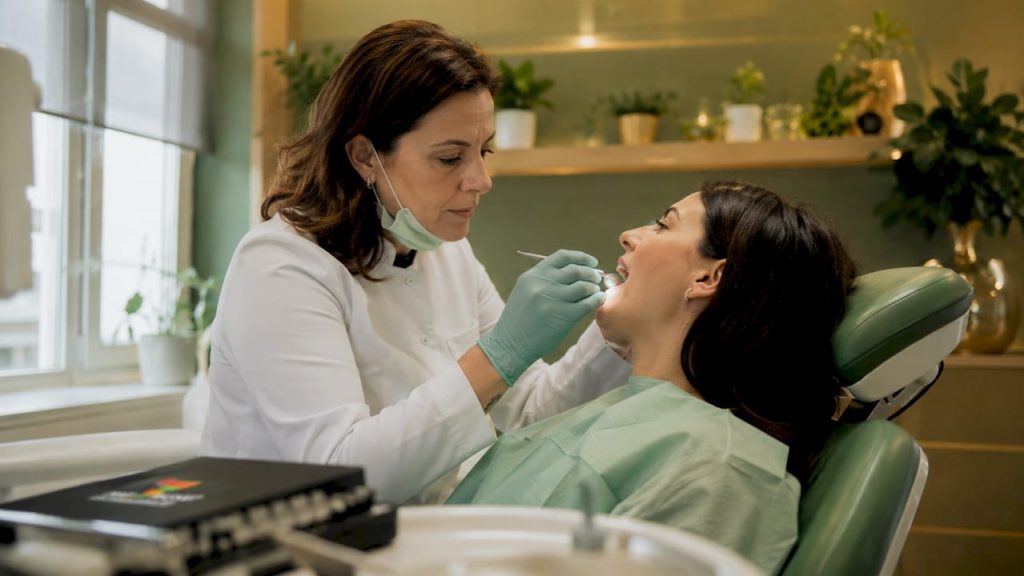 Medicul stomatolog consultă un pacient care se confruntă cu sensibilitate dentară