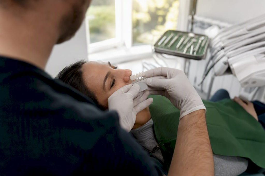 Mâinile dentistului țin fațete dentare ceramice